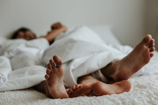 feet of a couple in a bed - stock image - sensuality lifestyles cheerful comfortable imagens e fotografias de stock