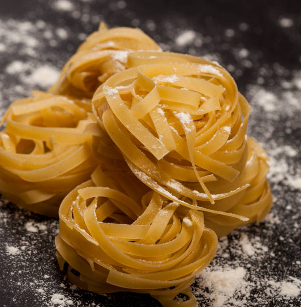 istock Italian traditional raw pasta on the black stone background 1147551191