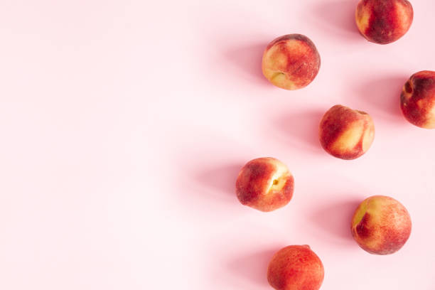 istock Peaches on pastel pink background. Frame made of fresh peaches. Flat lay, top view, copy space 1147551843