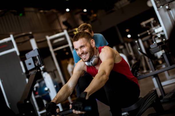 istock Young man with trainer doing exercise in the gym 1147552252