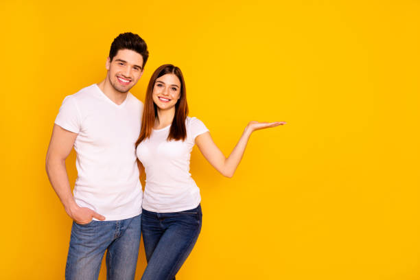 istock Close up photo two people she her he him his pair hold open palm empty space banner placard sale discount new black friday prices wear casual jeans denim white t-shirts isolated yellow background 1147554005