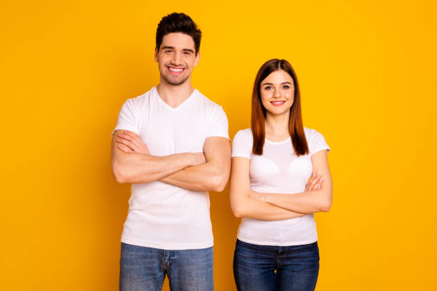 istock Close up photo beautiful cheer she her he him his pair stand side teamwork self-confident professionals specialists work job reliable workers wear casual white t-shirts isolated yellow background 1147554240