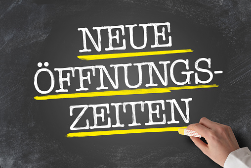 text NEUE Ã–FFNUNGSZEITEN, German for new opening hours or changed business hours, written on chalkboard