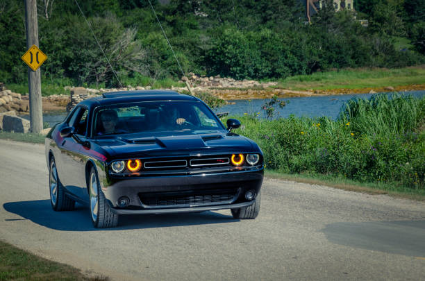 2010 Dodge Challenger Chester,  Nova Scotia, Canada - August 4, 2018 : Modern day muscle car, 2010 Dodge Challenger R/T entering annual Graves Island Car Show, Graves Island Provincial Park, Chester Nova Scotia. Driver and passenger appear to be enjoying the scenery. 2018 stock pictures, royalty-free photos & images