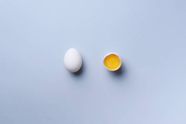 istock Food concept with broken egg and whole one on grey background. Top view. Creative pattern in minimal style. Flat lay 1147558671