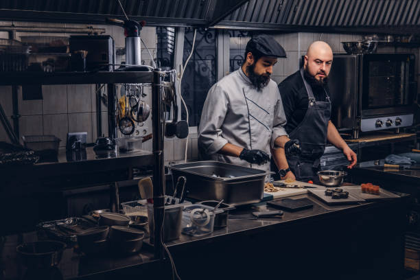 istock Two brutal cooks dressed in uniforms preparing sushi in a kitchen. 1147562952