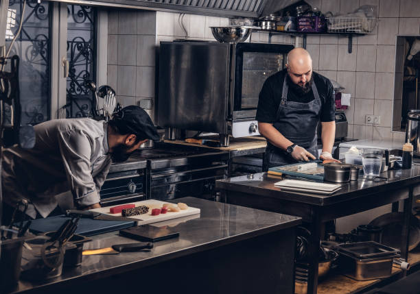 istock Two brutal cooks dressed in uniforms preparing sushi in a kitchen. 1147563211