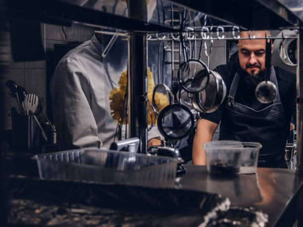 istock Two brutal cooks dressed in uniforms preparing sushi in a kitchen. 1147563277