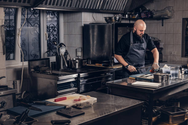 istock Brutal chef dressed in uniforms preparing sushi in the kitchen. 1147565518