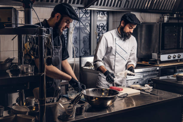 istock Two brutal cooks dressed in uniforms preparing sushi in a kitchen. 1147566231