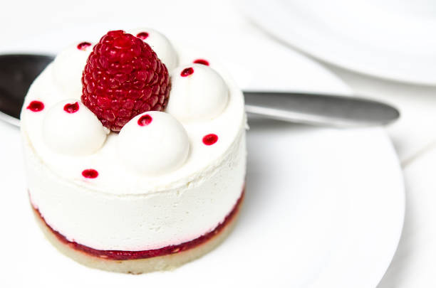 istock White airy cake with raspberry layer and raspberry berry lies on a white round plate next to a white cup, which stands on a white table 1147566705