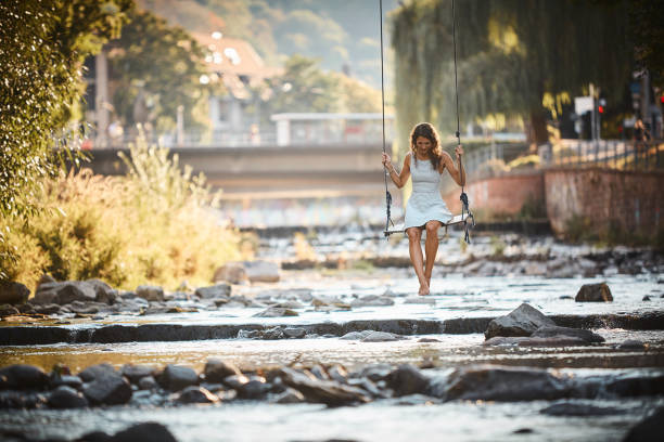 istock Young woman swings over stream 1147566795