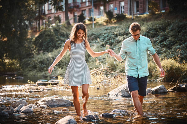 istock Couple hold hands in stream at sunset 1147566949