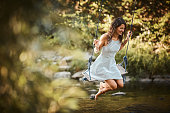Young woman swings over stream