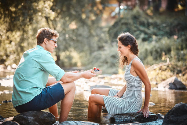 istock Couple have a picnic in stream at sunset 1147567040