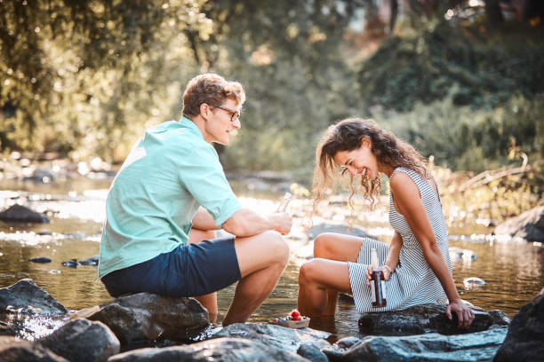 Couple have a picnic in stream at sunset