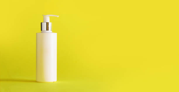 istock White bottle of moisturizing lotion on yellow background with copy space. Minimalism style. Skin care, body treatment, beauty concept 1147568931