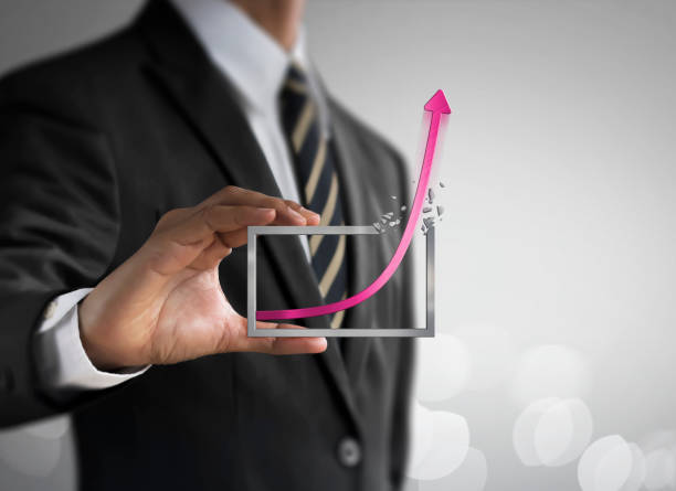 Business growth, progress or success concept. Businessman is holding a growing graph on bright tone background. stock photo