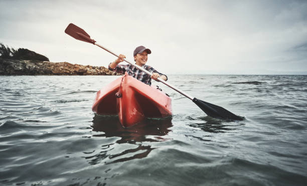 istock Teenage boy kayaking at sunset 1147573859