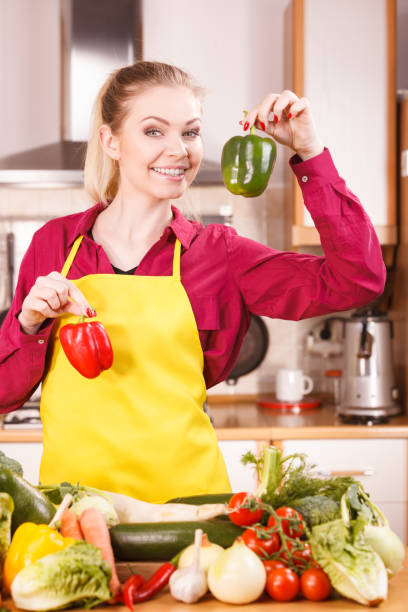 istock Woman holding two bell peppers 1147575297