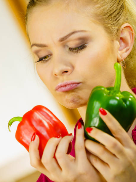 istock Woman holding bell peppers paprika thinking 1147575905