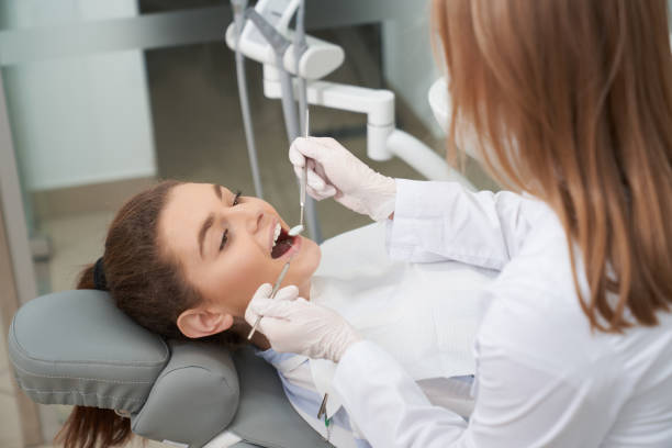 istock Patient lying on dentist chair with opened mouth. 1147577563