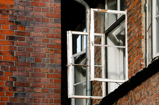 Open casement window on a dilapidated building
