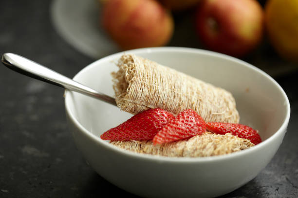 A close up of a bowl of cereal with fresh fruit on top