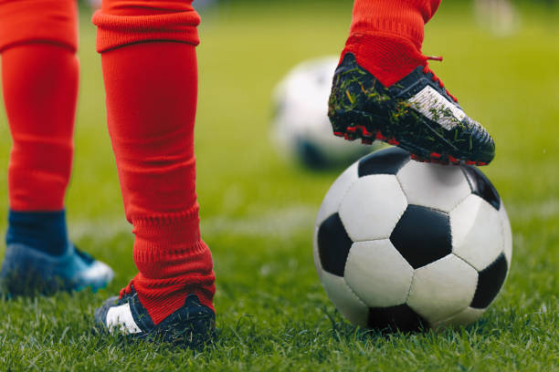istock Close up soccer player with ball on grass field 1147578239