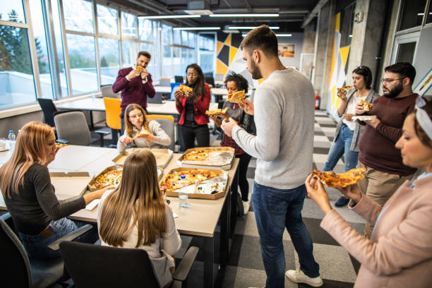 직장에서 바쁜 하루를 마친 후 모두가 너무 배가 고 픈 모습 - pizza eating african descent lunch 뉴스 사진 이미지