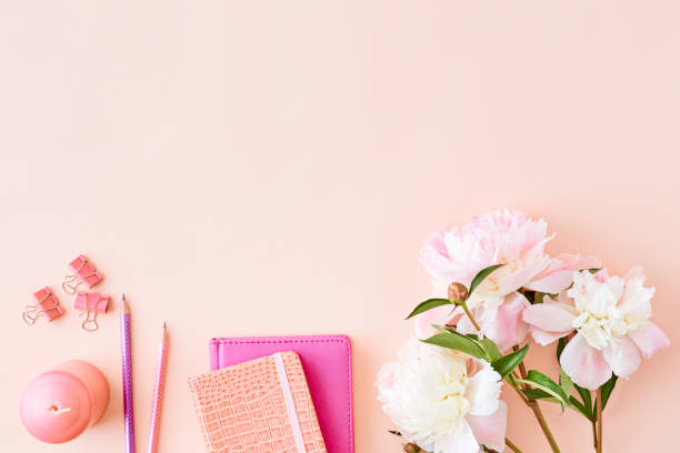 istock Blogger or freelancer workspace with notebook and light pink peonies on a pink background 1147579241
