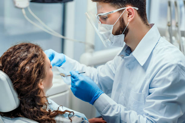 Healthcare and medicine concept. Dentist very carefully check up and repair tooth of his young female patient. Side view. dental hygienist stock pictures, royalty-free photos & images