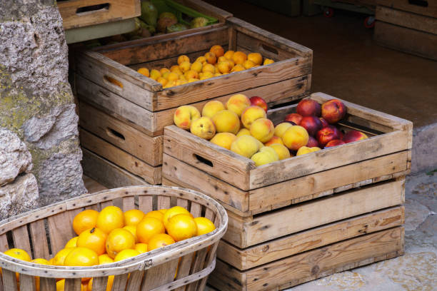 scelta di frutta fresca matura in scatole di legno in un mercato - nectarine peach red market foto e immagini stock