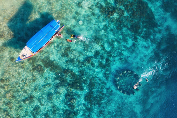 The people are snorkeling near the famous place on Gili Meno Island, Indonesia. Aerial view. Underwater tourism in the ocean. Gili Meno Island, Indonesia. Travel - image stock photo