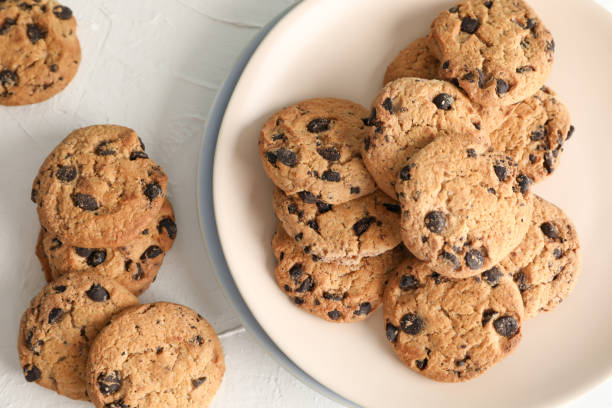 istock Plate with tasty chocolate chip cookies  on gray background, top view 1147585421