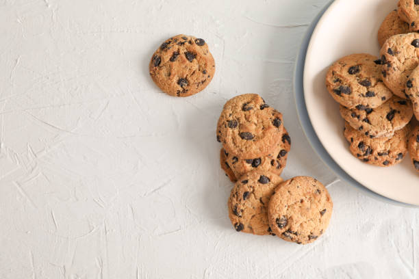 istock Plate with tasty chocolate chip cookies  on gray background, top view. Space for text 1147586468