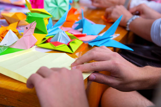 istock Hands of a man creating a colored origami paper. Creativity 1147586542