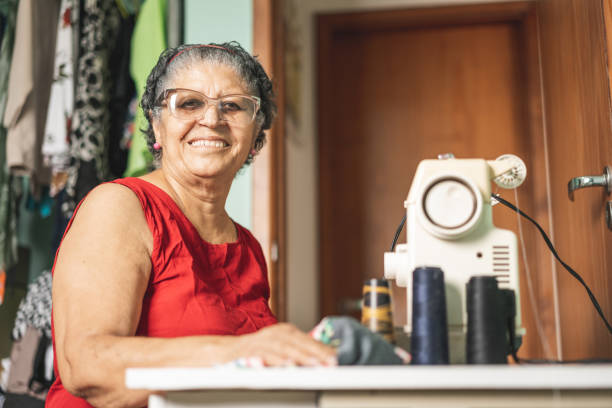 portrait of the professional seamstress - sewing tailor sewing machine women imagens e fotografias de stock