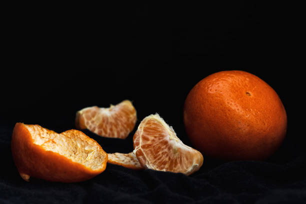istock Peeled orange with slices and peel, mystical light 1147589257