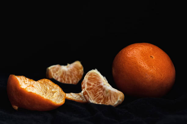 istock Peeled orange with slices and peel, mystical light 1147589282