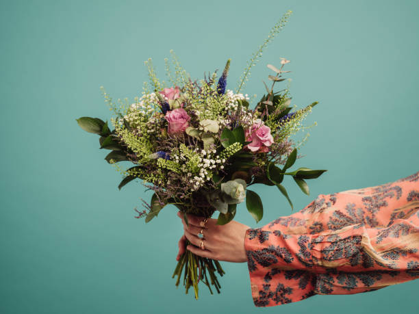 Woman holding a big bouquet of flowers Woman holding a big bouquet of flowers, arms only
Photo of hands and flowers in studio against turquoise bunch stock pictures, royalty-free photos & images
