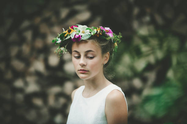 little girl looking down wearing a floral wreath, portrait