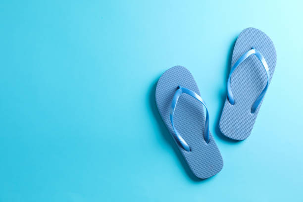 istock Flip flops on color background, space for text. Summer vacation backdrop 1147592870
