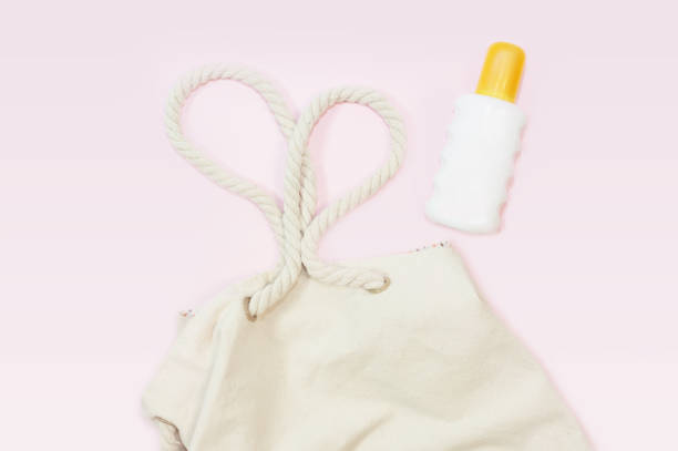 istock beach bag with beach top view with sunscreen on pink background 1147595779