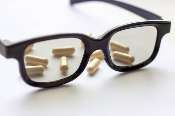 istock Capsules with glasses on light background. Pharmacy and medicine concept. Focused on a pharmaceutical industry for eye diseases 1147598046