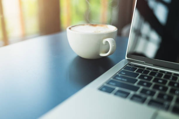 istock Latte coffee in a white coffee mug and laptop 1147599823