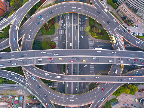 Aerial view of highway junctions with roundabout. Bridge roads shape circle in structure of architecture and transportation concept. Top view. Urban city, Shanghai, China.