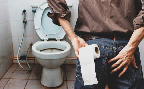 istock man holding tissue roll in dirty toilet 1147608068