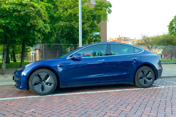 Tesla Model 3 electric car in blue parked on the street Tesla Model 3 electric car in blue parked on the street in Zwolle, Netherlands. The Model 3 is the smallest Tesla electric car and can is fitted with a battery of a 220 mi (354 km) Standard, 264 mi (425 km) Mid or 325 mi (523 km) Long range. tesla model 3 stock pictures, royalty-free photos & images