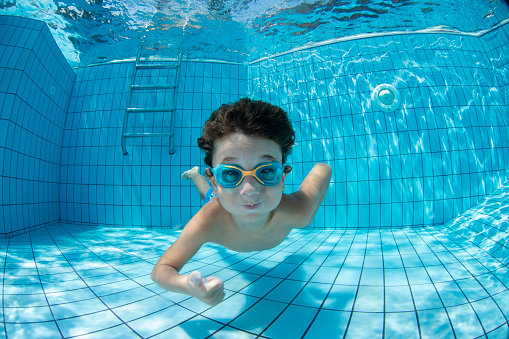 Niño submarino divertido en la piscina con gafas photo